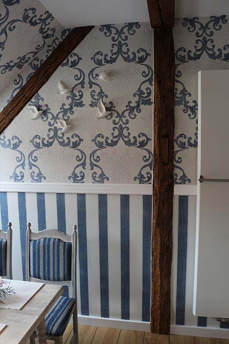 In blau-weiß gehaltene Küche, blaue Ornamente und Streifen an der Wand