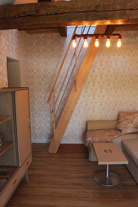 Wohnzimmer tapeziert mit hellerStrukturtapete und warmer Beleuchtung
