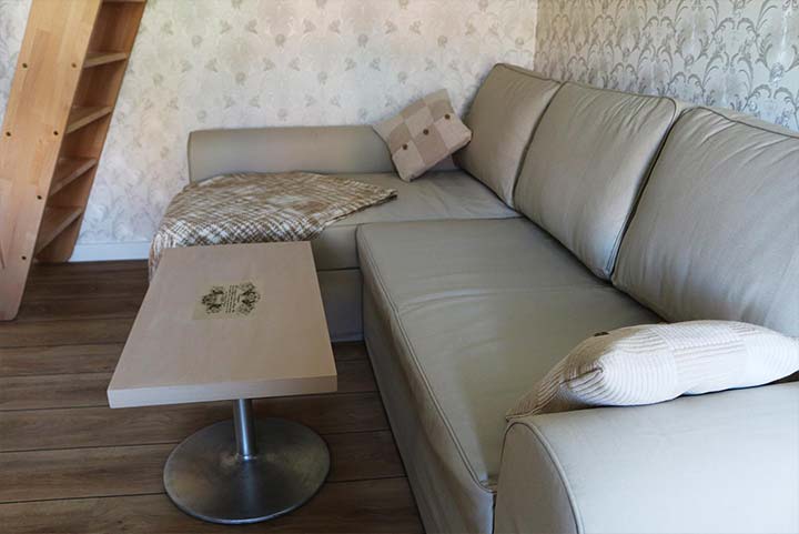 Wohnzimmer tapeziert mit hellerStrukturtapete und grauem Sofa