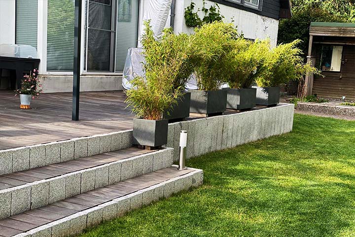 gepflegter Rasen mit Treppe zu einer Veranda
